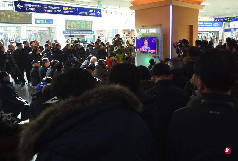 朴槿惠昨天下午2时半向全国发表电视讲话,表示愿意提早下台。图为首尔一个火车站内,人们驻足聆听。(法新社) 朴槿惠昨天下午2时半向全国发表电视讲话,表示愿意提早下台。图为首尔一个火车站内,人们驻足聆听。(法新社)