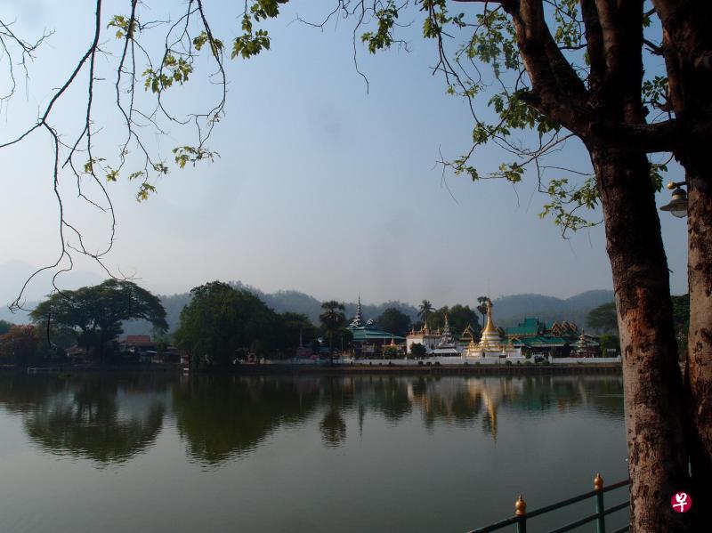 琼昆湖畔平静的水面倒映出寺庙的建筑轮廓，景色优美。