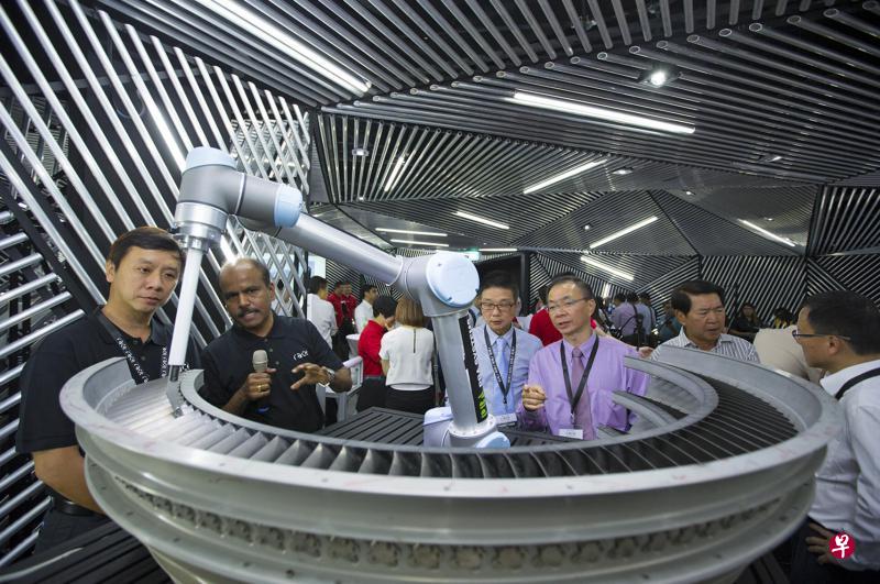 本地首个专为提升工业机械操作与运用技能的机器人应用培训与教育计划昨天正式推出。职总就业与职能培训中心总裁陈财喜(左一)参观机器人应用精益中心,了解机械手如何为飞机引擎盖进行维修。 本地首个专为提升工业机械操作与运用技能的机器人应用培训与教育计划昨天正式推出。职总就业与职能培训中心总裁陈财喜(左一)参观机器人应用精益中心,了解机械手如何为飞机引擎盖进行维修。