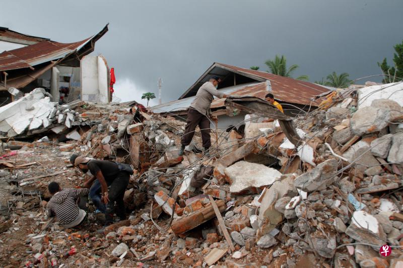 印尼派出军警、救援人员前往地震灾区救援,全力抢救被埋居民,并不断有遇难者遗体被发现,预计死亡人数还会上升。图为当地居民在地震废墟中寻找幸存者。(Getty Images) 印尼派出军警、救援人员前往地震灾区救援,全力抢救被埋居民,并不断有遇难者遗体被发现,预计死亡人数还会上升。图为当地居民在地震废墟中寻找幸存者。(Getty Images)