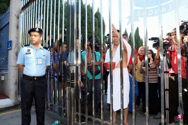 嘉马(中)身穿“沐浴服”到雪州政府大厦借厕所洗澡,但被保安人员挡在铁门外。(东方日报) 嘉马(中)身穿“沐浴服”到雪州政府大厦借厕所洗澡,但被保安人员挡在铁门外。(东方日报)