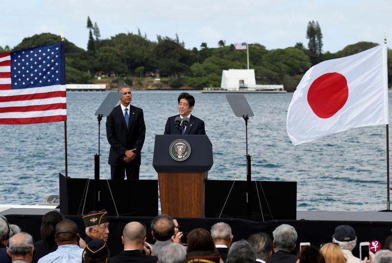 日本首相安倍晋三(右)与美国总统奥巴马在亚利桑那号战舰纪念馆致哀后,一同在附近码头发表演讲。(路透社) 日本首相安倍晋三(右)与美国总统奥巴马在亚利桑那号战舰纪念馆致哀后,一同在附近码头发表演讲。(路透社)