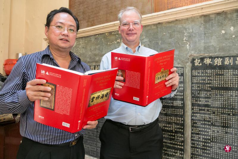许源泰博士(左)和丁荷生教授手捧着《新加坡华文铭刻汇编1819-1911》上下册摄于番禺会馆的碑铭前。(徐颖荃摄) 许源泰博士(左)和丁荷生教授手捧着《新加坡华文铭刻汇编1819-1911》上下册摄于番禺会馆的碑铭前。(徐颖荃摄)