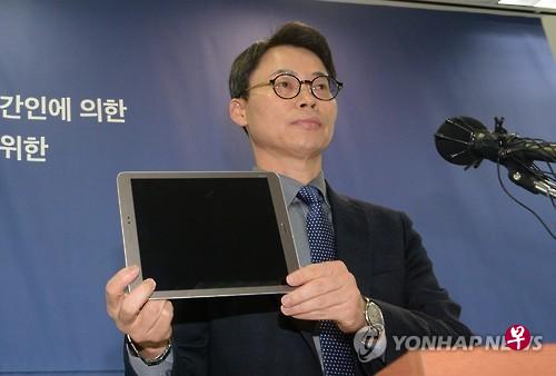 韩国独立检察组发言人李圭喆在记者会上出示崔顺实的平板电脑。(韩联社) 韩国独立检察组发言人李圭喆在记者会上出示崔顺实的平板电脑。(韩联社)