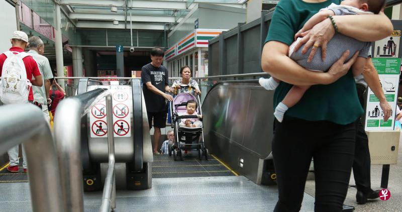 繁忙的莱佛士坊地铁站刚发生电扶梯踏板翘起,卡到婴儿手推车轮子事故,不过昨天仍有不少家长把婴儿手推车带上电扶梯。(陈福洲摄) 繁忙的莱佛士坊地铁站刚发生电扶梯踏板翘起,卡到婴儿手推车轮子事故,不过昨天仍有不少家长把婴儿手推车带上电扶梯。(陈福洲摄)