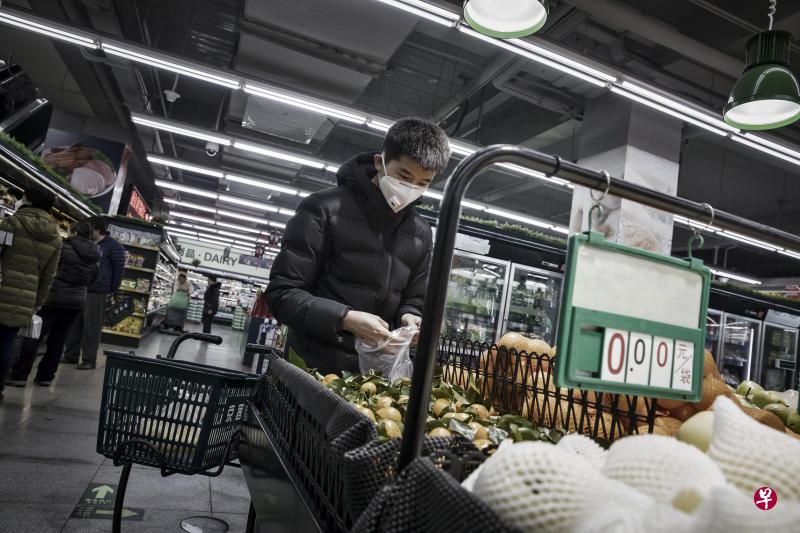 在今年初的雾霾天里,一名北京市民在超市里戴着口罩选购水果。有志愿者上个月检测后发现,北京多数公共场所的室内空气并不达标。(彭博社) 在今年初的雾霾天里,一名北京市民在超市里戴着口罩选购水果。有志愿者上个月检测后发现,北京多数公共场所的室内空气并不达标。(彭博社)