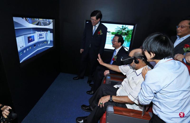 赛哈密(坐者右一)参观中国高铁项目时,佩戴3D器材感受乘搭高铁的立体景象感。左起为杨忠民及黄惠康。(星洲日报) 赛哈密(坐者右一)参观中国高铁项目时,佩戴3D器材感受乘搭高铁的立体景象感。左起为杨忠民及黄惠康。(星洲日报)