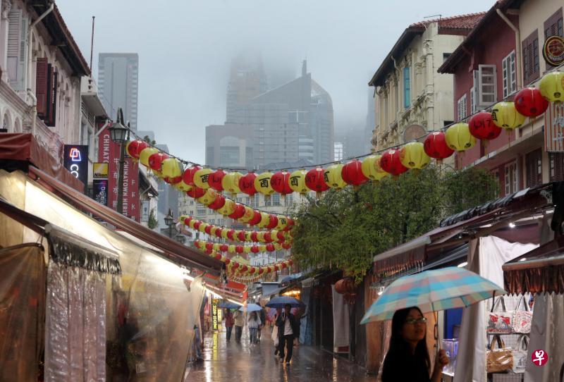 乌云满天,雨滴不断飘落,不少公众撑起雨伞,在雨中添购年货。(邬福梁摄) 乌云满天,雨滴不断飘落,不少公众撑起雨伞,在雨中添购年货。(邬福梁摄)