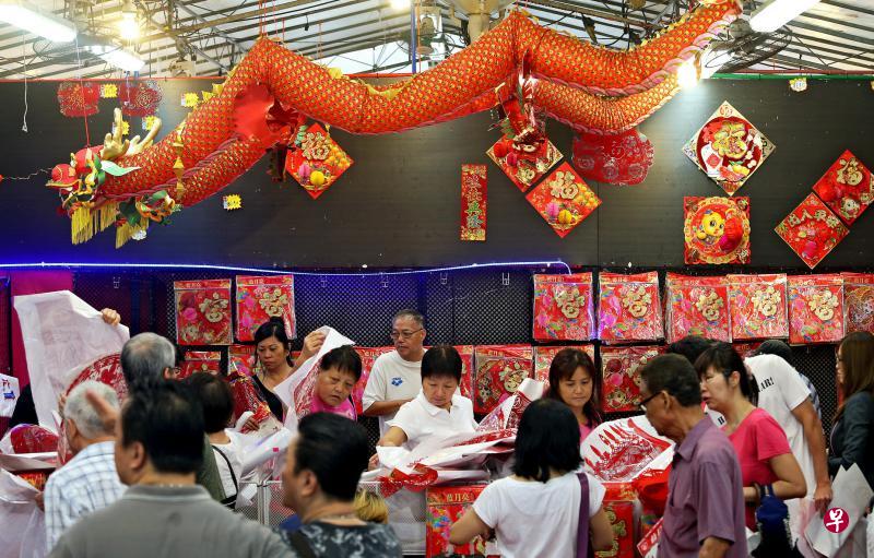 宏茂桥组屋区的百货商店昨天免费赠送新年装饰品,许多公众兴致勃勃地挑选对联、福贴和剪纸。(叶振忠摄) 宏茂桥组屋区的百货商店昨天免费赠送新年装饰品,许多公众兴致勃勃地挑选对联、福贴和剪纸。(叶振忠摄)