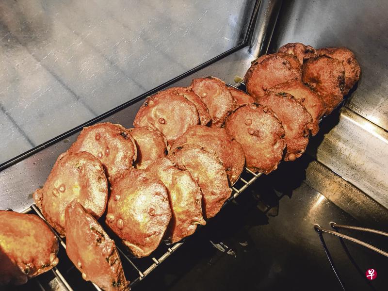 炸好的蚝饼捞起放在铁架沥干油分。 炸好的蚝饼捞起放在铁架沥干油分。