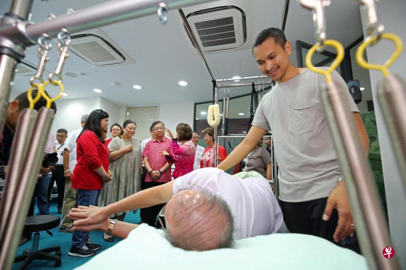 翻新后的黄埔民众俱乐总面积比之前增加约八成,设有乐龄综合服务中心,以多管齐下方式促进年长者的身心健康。图为卫生部长颜金勇(后排左三)了解中心如何为年长者提供物理治疗。(陈福洲摄) 翻新后的黄埔民众俱乐总面积比之前增加约八成,设有乐龄综合服务中心,以多管齐下方式促进年长者的身心健康。图为卫生部长颜金勇(后排左三)了解中心如何为年长者提供物理治疗。(陈福洲摄)