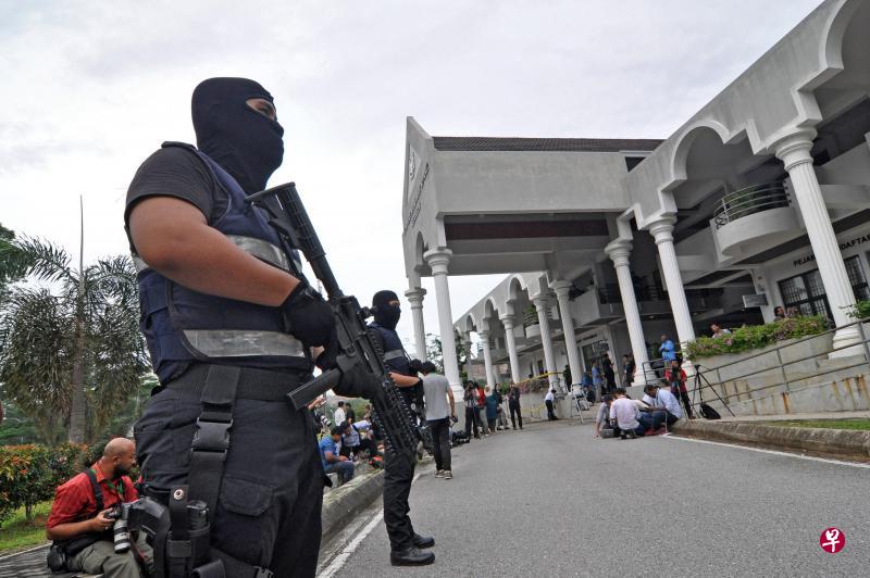 马国警方出动上百名全副武装的警员在法庭四周驻守,大阵仗的戒备场面十分罕见。(新华社) 马国警方出动上百名全副武装的警员在法庭四周驻守,大阵仗的戒备场面十分罕见。(新华社)