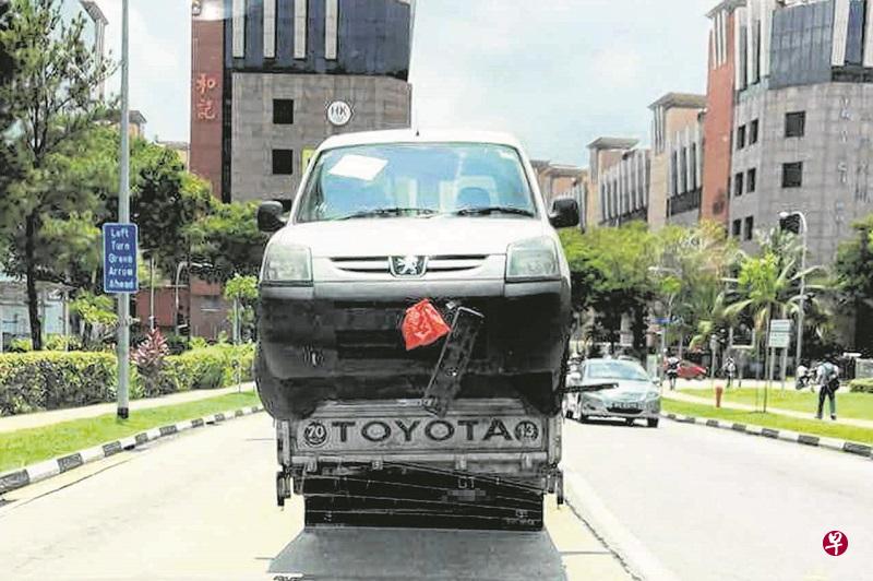 货车违规“载”汽车，车头摇摇欲坠。（取自面簿）