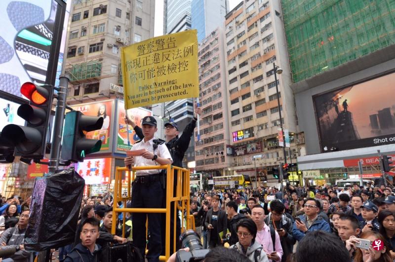 民阵未向警方申请即发起游行集会，警方在场一度高举黄旗警告参加者。（星岛日报）