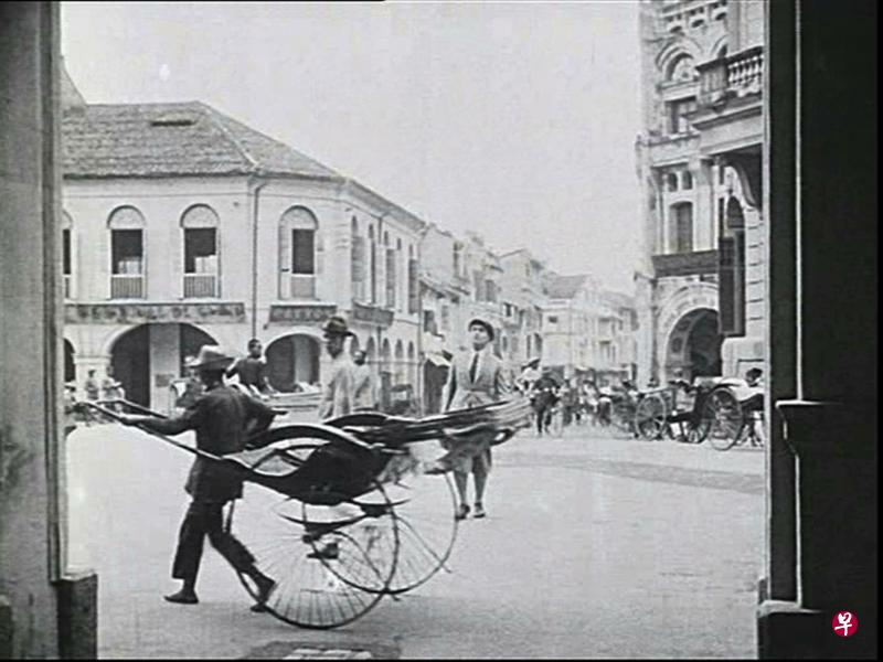 1925年德国默片《环绕世界飞行》的男主角站在当年的莱佛士坊路上。如今,这一带景观已完全改变。(谢智扬摄/取自‘环绕世界飞行’) 1925年德国默片《环绕世界飞行》的男主角站在当年的莱佛士坊路上。如今,这一带景观已完全改变。(谢智扬摄/取自‘环绕世界飞行’)