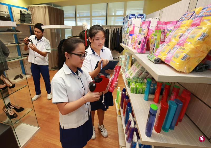 义顺中学中三生吴殷瑶(右起)、卓倩绮和穆罕默德在校内新设的零售中心练习点货、排列产品等,实践课堂上的知识。(唐家鸿摄) 义顺中学中三生吴殷瑶(右起)、卓倩绮和穆罕默德在校内新设的零售中心练习点货、排列产品等,实践课堂上的知识。(唐家鸿摄)