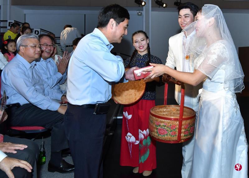 阿福在大喜之日和新娘一道送喜饼,总理公署高级政务部长王志豪掏出红包给新人贺喜。(福建会馆提供) 阿福在大喜之日和新娘一道送喜饼,总理公署高级政务部长王志豪掏出红包给新人贺喜。(福建会馆提供)