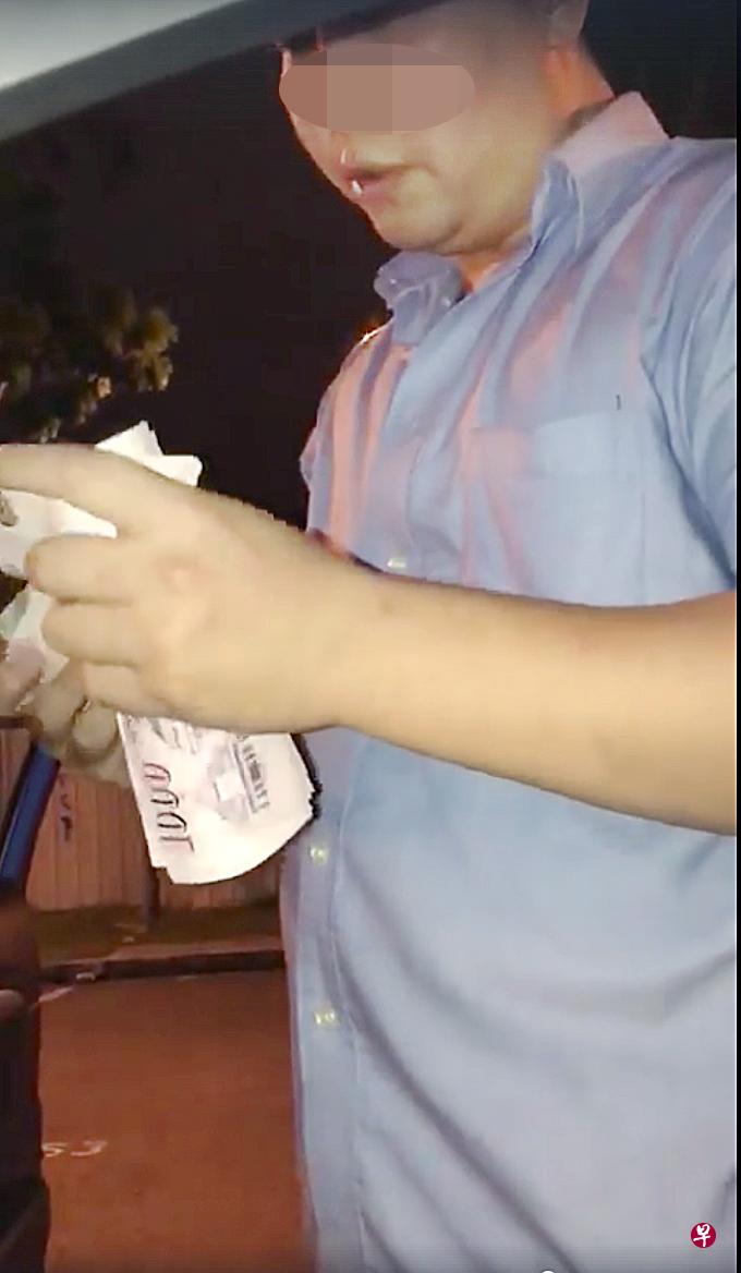 男子掏出一叠 千元钞票,在司机 的面前数了起来。(视频截图) 男子掏出一叠 千元钞票,在司机 的面前数了起来。(视频截图)