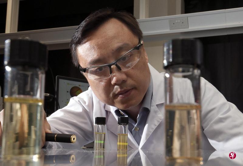 刘小钢教授所研发的纳米晶体能系上药物,更有针对性地注入人体含有癌细胞的部位。他表示,这除了能减少不必要的人体伤害,药量也将减少,因而降低医药成本。图为刘小钢以肉眼看不见的近红外线照射含纳米晶体的液体,呈现出不同颜色。(邬福梁摄) 刘小钢教授所研发的纳米晶体能系上药物,更有针对性地注入人体含有癌细胞的部位。他表示,这除了能减少不必要的人体伤害,药量也将减少,因而降低医药成本。图为刘小钢以肉眼看不见的近红外线照射含纳米晶体的液体,呈现出不同颜色。(邬福梁摄)