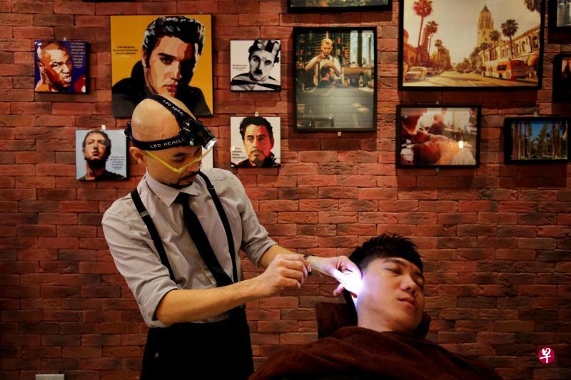 LA Barbershop的理发师黄燕香有30年丰富经验，他在为男士理发的同时也提供采耳服务。（龙国雄摄影）