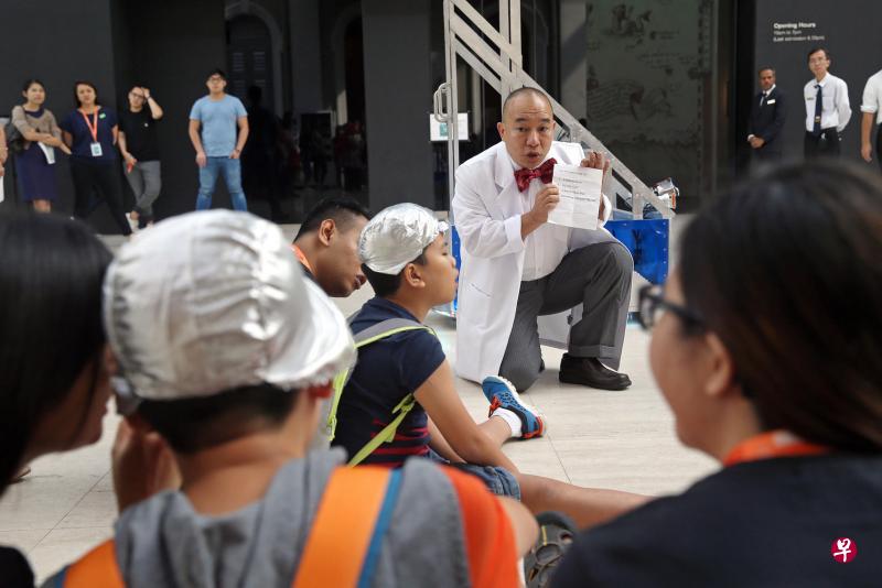 国家博物馆和本地的超级未来剧团合作,推出结合互动剧场和教育导览的“时光机历险记”活动,让特需孩童也能参观博物馆,了解本地历史。图为剧场演员符永春(白色大衣者)向参与活动的孩童进行讲解。(海峡时报) 国家博物馆和本地的超级未来剧团合作,推出结合互动剧场和教育导览的“时光机历险记”活动,让特需孩童也能参观博物馆,了解本地历史。图为剧场演员符永春(白色大衣者)向参与活动的孩童进行讲解。(海峡时报)