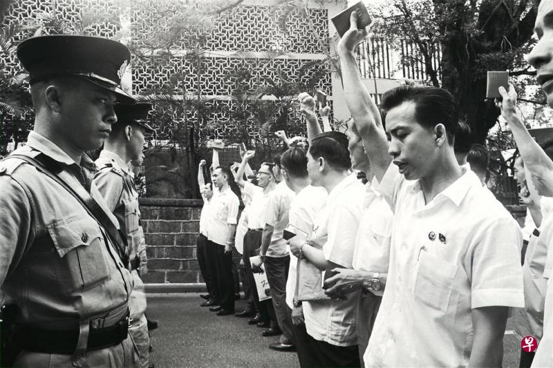 香港左派抗议者1967年5月16日“六七暴动”期间在南九龙裁判署外手挥《毛主席语录》高喊口号,与警察对峙。 (法新社∕南华早报∕LOOK) 香港左派抗议者1967年5月16日“六七暴动”期间在南九龙裁判署外手挥《毛主席语录》高喊口号,与警察对峙。 (法新社∕南华早报∕LOOK)