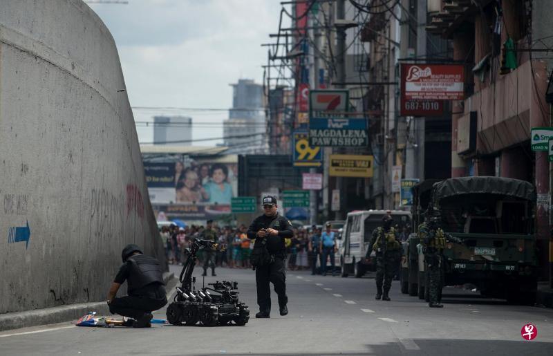 菲律宾爆炸专家昨天依旧在奎阿坡搜索前晚两次爆炸案的蛛丝马迹。图中两名拆爆专家正在检查一个可疑包裹。(法新社) 菲律宾爆炸专家昨天依旧在奎阿坡搜索前晚两次爆炸案的蛛丝马迹。图中两名拆爆专家正在检查一个可疑包裹。(法新社)