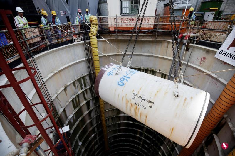 起重机把一节水管吊进竖井内,准备顶入土层,再连接成管道。(陈渊庄摄) 起重机把一节水管吊进竖井内,准备顶入土层,再连接成管道。(陈渊庄摄)