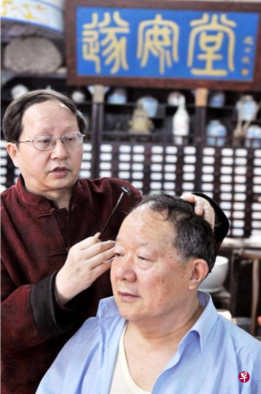 “刘氏针灸刺熨疗法”传承人刘光瑞（左），示范疗法。