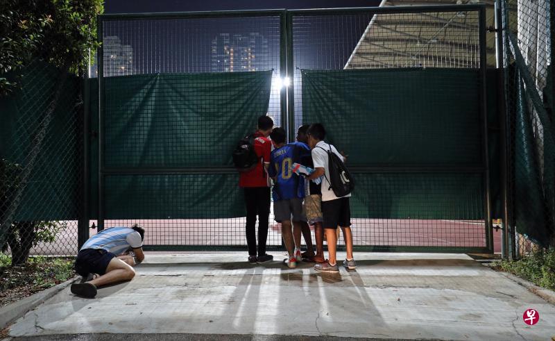 阿根廷队昨天在碧山体育场闭门训练,球迷们只能在场边透过缝隙偷看。(林泽锐摄) 阿根廷队昨天在碧山体育场闭门训练,球迷们只能在场边透过缝隙偷看。(林泽锐摄)