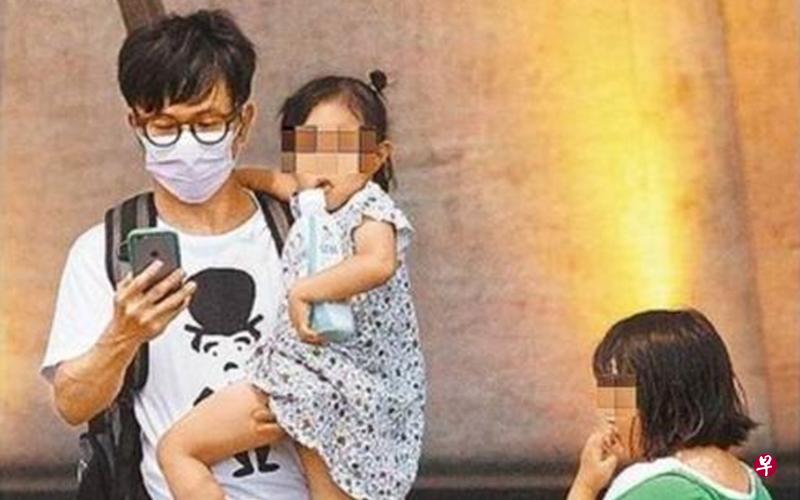 台湾苹果日报直击唐从圣带着两个小女孩在路边等车。 台湾苹果日报直击唐从圣带着两个小女孩在路边等车。