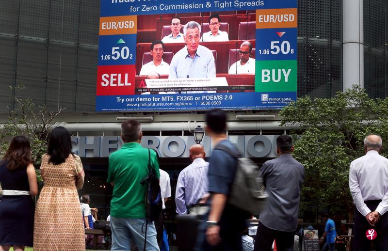 李光耀故居争端受到举国上下瞩目,不少公众昨天在莱佛士坊地铁站外的大荧幕前,驻足观看李显龙总理就这起争端发表声明的新闻报道。(何家俊摄) 李光耀故居争端受到举国上下瞩目,不少公众昨天在莱佛士坊地铁站外的大荧幕前,驻足观看李显龙总理就这起争端发表声明的新闻报道。(何家俊摄)