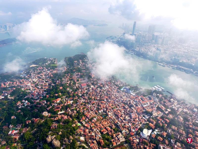空中俯瞰,云层下的鼓浪屿历史风貌街区或隐或现,与对岸的厦门现代都市遥相辉映(新华社) 空中俯瞰,云层下的鼓浪屿历史风貌街区或隐或现,与对岸的厦门现代都市遥相辉映(新华社)