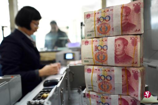 一名银行职员点算人民币100元纸钞。(法新社) 一名银行职员点算人民币100元纸钞。(法新社)