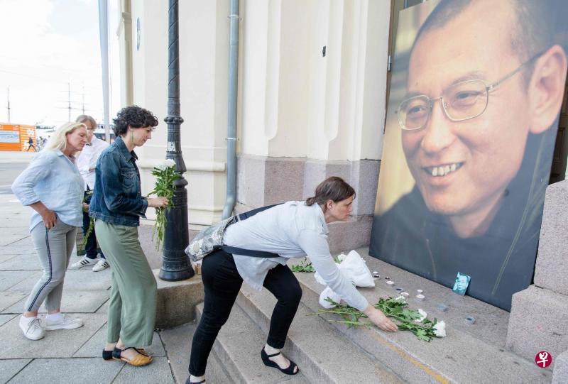 刘晓波病逝的消息传出后,挪威首都奥斯陆市民纷纷到诺贝尔和平中心外给刘晓波的巨幅照片献花与点燃蜡烛。(路透社) 刘晓波病逝的消息传出后,挪威首都奥斯陆市民纷纷到诺贝尔和平中心外给刘晓波的巨幅照片献花与点燃蜡烛。(路透社)
