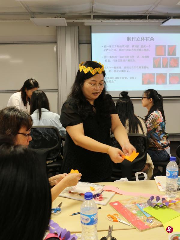 学前华文教师陈美雅与同行分享如何通过剪纸活动训练孩子的创造能力,示范如何制作立体花。(推广华文学习委员会提供) 学前华文教师陈美雅与同行分享如何通过剪纸活动训练孩子的创造能力,示范如何制作立体花。(推广华文学习委员会提供)