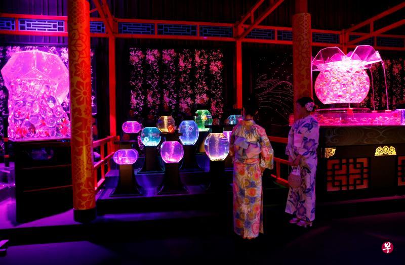 两名参观者正在东京桥三井会馆里观赏色彩缤纷的金鱼。(路透社) 两名参观者正在东京桥三井会馆里观赏色彩缤纷的金鱼。(路透社)