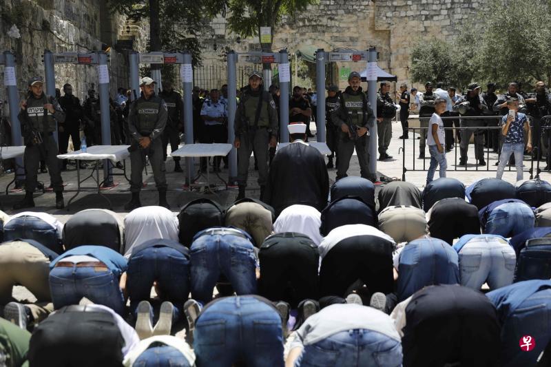 由于不满阿萨克清真寺入口处加装了金属探测器和摄像机,数十名穆斯林拒绝入内礼拜。(法新社) 由于不满阿萨克清真寺入口处加装了金属探测器和摄像机,数十名穆斯林拒绝入内礼拜。(法新社)