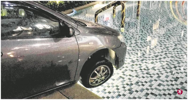 司机急忙刹车,但车子前轮还是进入水池。 司机急忙刹车,但车子前轮还是进入水池。