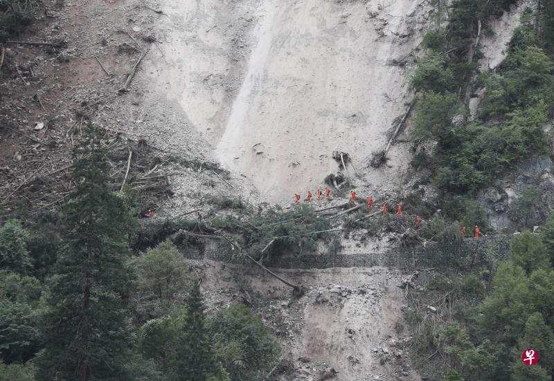一组搜救人员徒步通过九寨沟景区五花海到熊猫海的滑坡地段,当地余震不断,随时可能发生山体滑坡。(新华社) 一组搜救人员徒步通过九寨沟景区五花海到熊猫海的滑坡地段,当地余震不断,随时可能发生山体滑坡。(新华社)