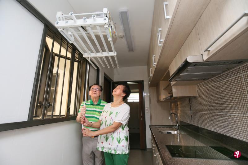退休夫妇张鸿方（左）和许惠娥是首批领取海军部村庄新居钥匙的屋主之一，他们对于小型公寓内的亲乐龄设备如伸缩式晾衣架感到满意。（何家俊摄）