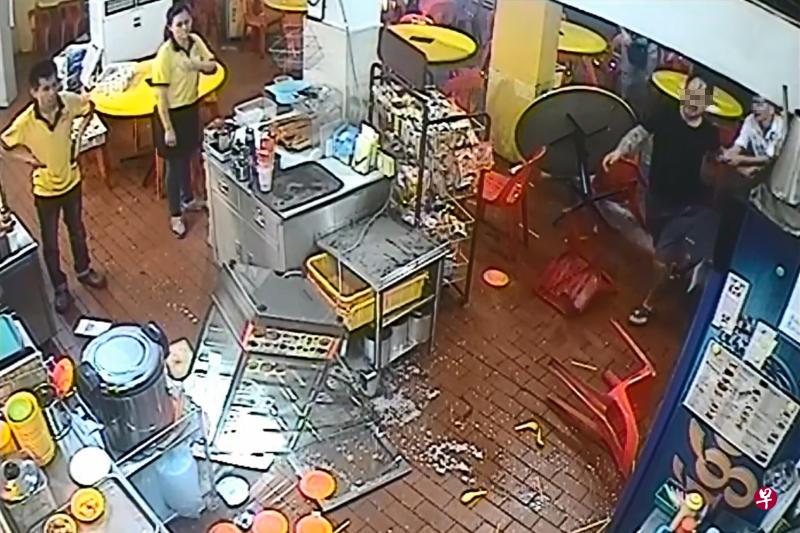 黑衣男砸了蒸箱后还不罢休，被白衣男拉住手劝阻。（视频截图）