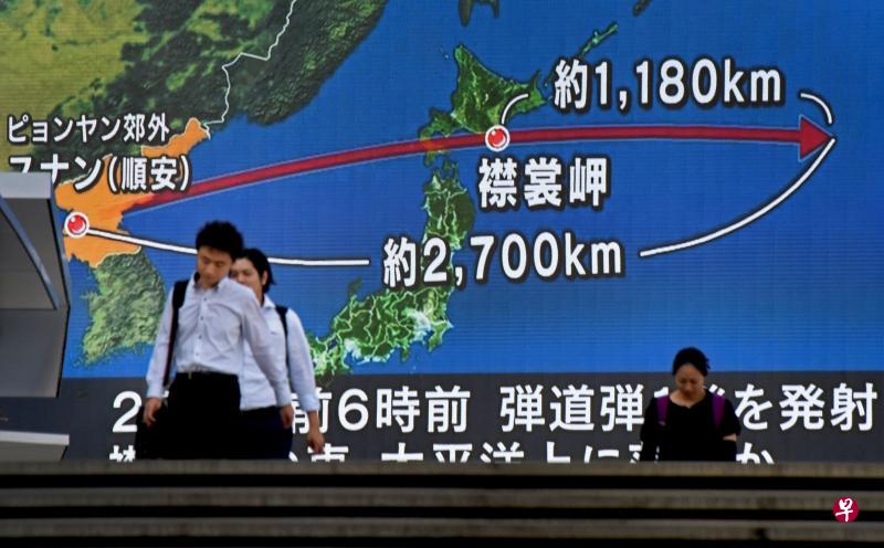 朝鲜导弹昨天飞过日本北部令日本全国震惊。在首都东京，户外大屏幕上显示朝鲜导弹飞跃北海道襟裳岬的示意图。（法新社）