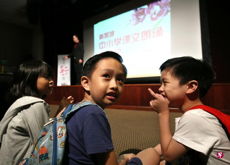 近300人出席昨天在兀兰区域图书馆礼堂举办的新加坡中小学课文朗诵观摩会,由于场地爆满,部分观众席地而坐。图为随父母前来观看观摩会的小朋友,坐在观众席台阶上观赏演出。(邝启聪摄) 近300人出席昨天在兀兰区域图书馆礼堂举办的新加坡中小学课文朗诵观摩会,由于场地爆满,部分观众席地而坐。图为随父母前来观看观摩会的小朋友,坐在观众席台阶上观赏演出。(邝启聪摄)