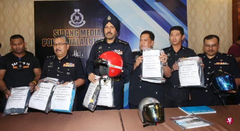 吉隆坡总警长阿马星(左三)昨晚在记者会上宣布侦破宗教学校夺命大火案,并展示七名嫌犯干案时所穿的衣服和安全钢盔。(星洲日报) 吉隆坡总警长阿马星(左三)昨晚在记者会上宣布侦破宗教学校夺命大火案,并展示七名嫌犯干案时所穿的衣服和安全钢盔。(星洲日报)