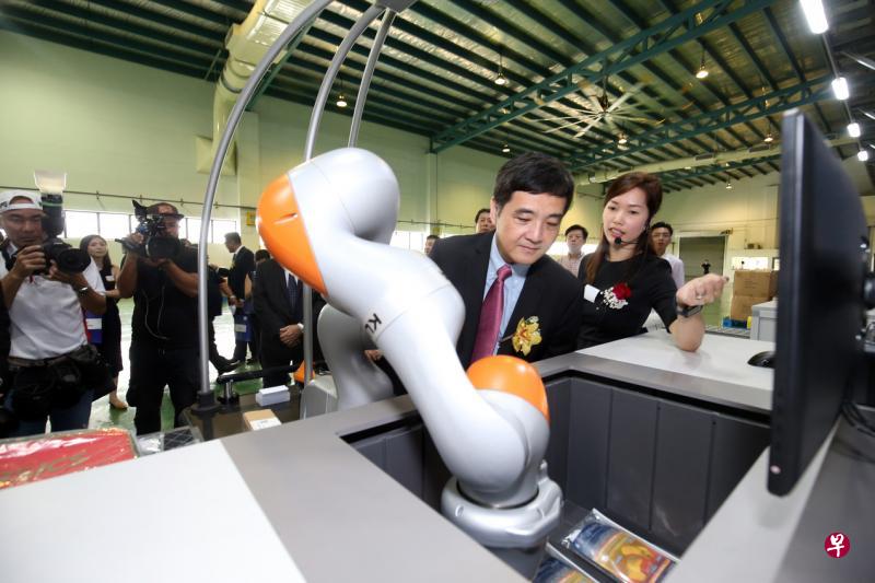 职总副秘书长、总理公署高级政务部长王志豪在自动化仓库的工作站,了解机器臂如何操作。(邝启聪摄) 职总副秘书长、总理公署高级政务部长王志豪在自动化仓库的工作站,了解机器臂如何操作。(邝启聪摄)