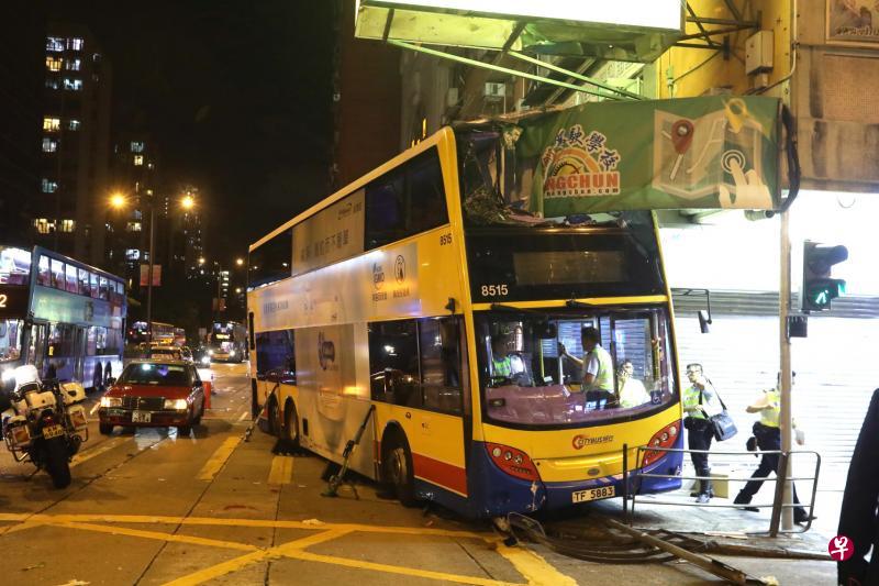 香港双层巴士失控冲上人行道,除了将多名路人卷入车底,上层更被路边大厦的水泥檐篷削成两截。(新华社) 香港双层巴士失控冲上人行道,除了将多名路人卷入车底,上层更被路边大厦的水泥檐篷削成两截。(新华社)