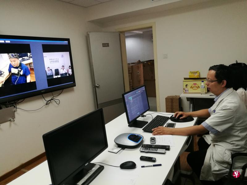 北京天坛医院神经外科主任医师孟凡刚(前),与新加坡国大医院神经外科主管姚进财,为身在新加坡的帕金森患者林先生进行脑深部刺激(DBS)术后远程会诊。(孟丹丹摄) 北京天坛医院神经外科主任医师孟凡刚(前),与新加坡国大医院神经外科主管姚进财,为身在新加坡的帕金森患者林先生进行脑深部刺激(DBS)术后远程会诊。(孟丹丹摄)