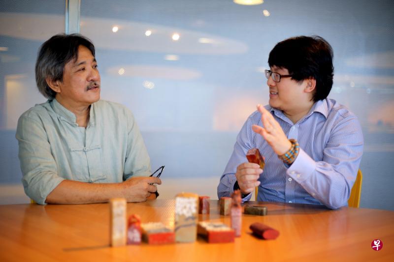 篆刻家陈振文(左)和科研员谢伟昇博士互看所刻印章,切磋篆刻艺术。 篆刻家陈振文(左)和科研员谢伟昇博士互看所刻印章,切磋篆刻艺术。