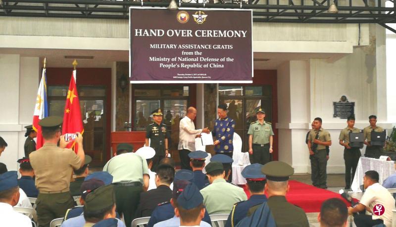 中国驻菲大使赵鉴华和菲防长洛伦扎纳上周四在悬挂中菲两国国防部标志的背景板下握手合照,却没发现竟用了台湾国防部徽章(小图)。(中新社) 中国驻菲大使赵鉴华和菲防长洛伦扎纳上周四在悬挂中菲两国国防部标志的背景板下握手合照,却没发现竟用了台湾国防部徽章(小图)。(中新社)